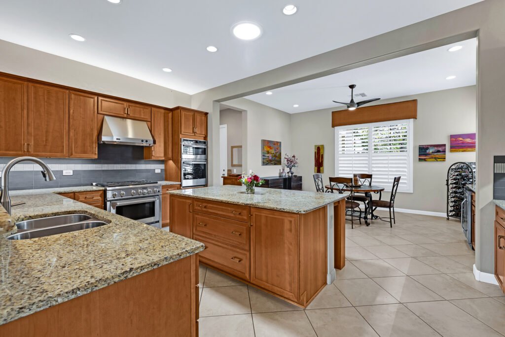 Gray paint in two colors, medium wood finish, stainless appliances and gray backsplash tile.