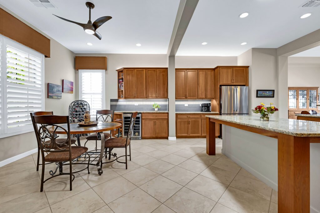 medium wood tone cabinet gray wall paint in two colors modern fan kitchen island and round table with metal back chairs stainless refrigerator